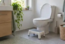 Helles Badezimmer mit Toilette und stabiler Fußstütze