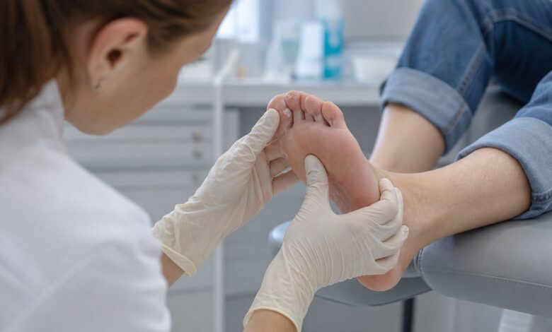 Dermatologin untersucht juckende Haut zwischen den Zehen