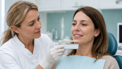 Zahnärztin bestimmt vor einem Zahnbleaching die Zahnfarbe einer Patientin